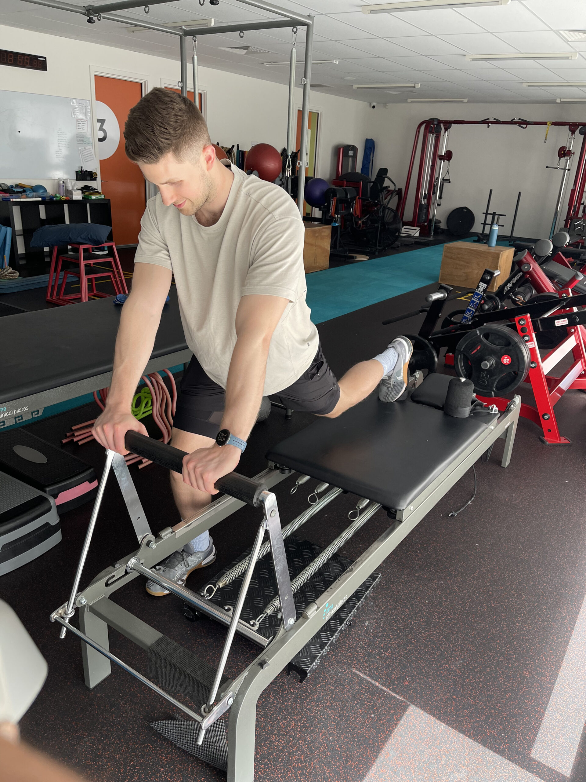 A man using gym equipment as part of a clinical pilates program in a studio