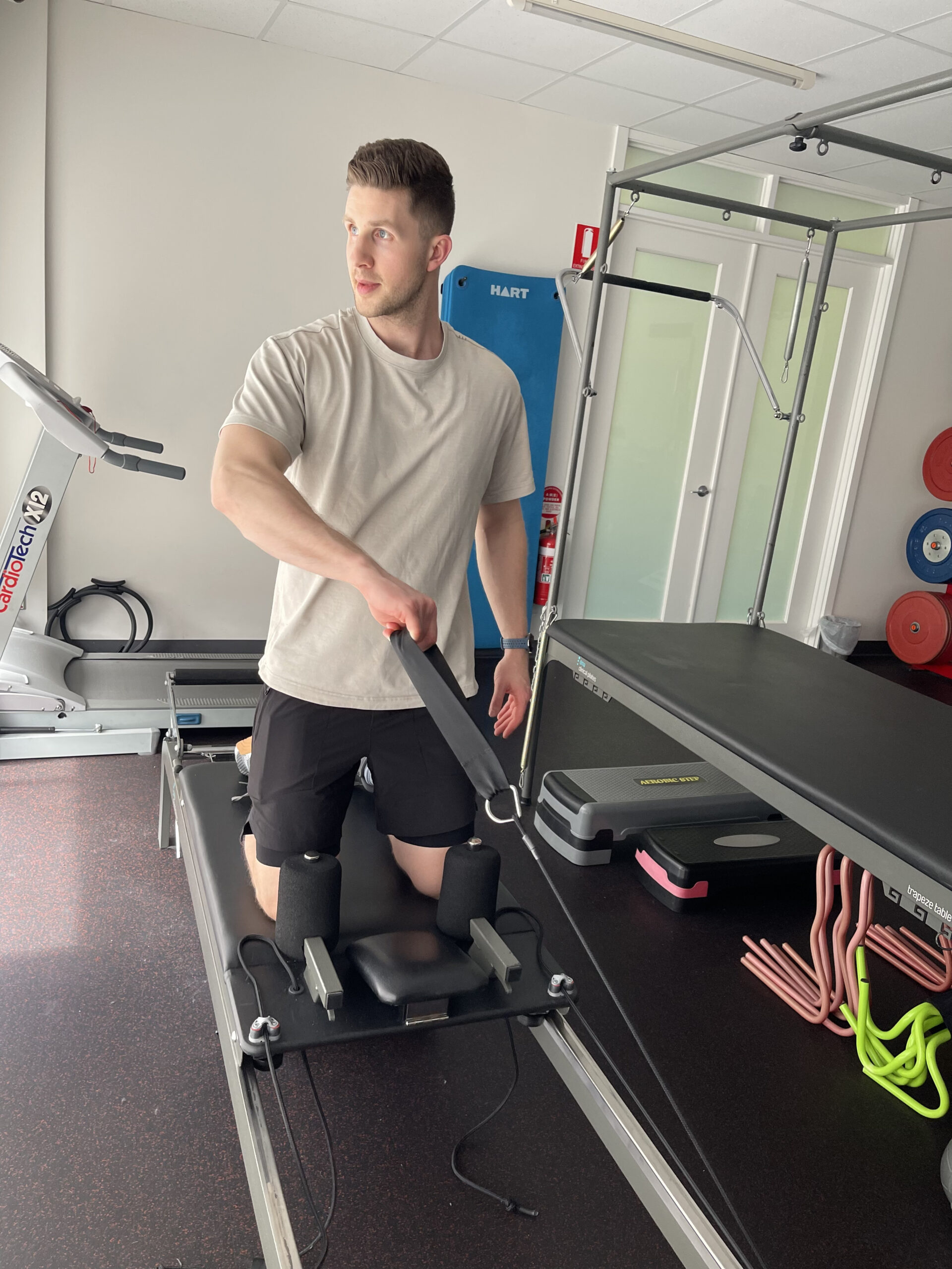 A patient using gym equipment during a clinical pilates session in a studio