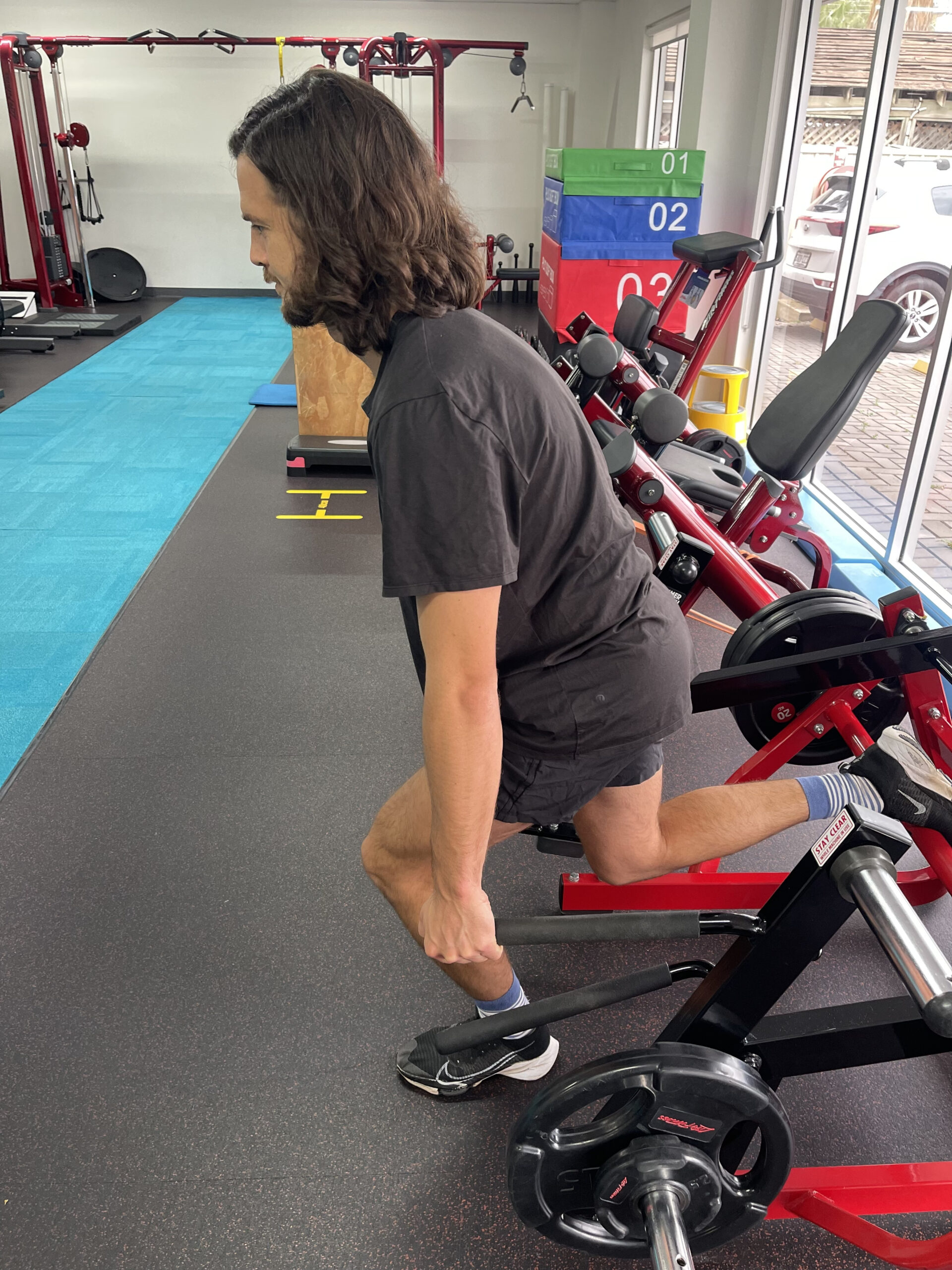 A patient using gym equipment as part of a sports physio session in Adelaide