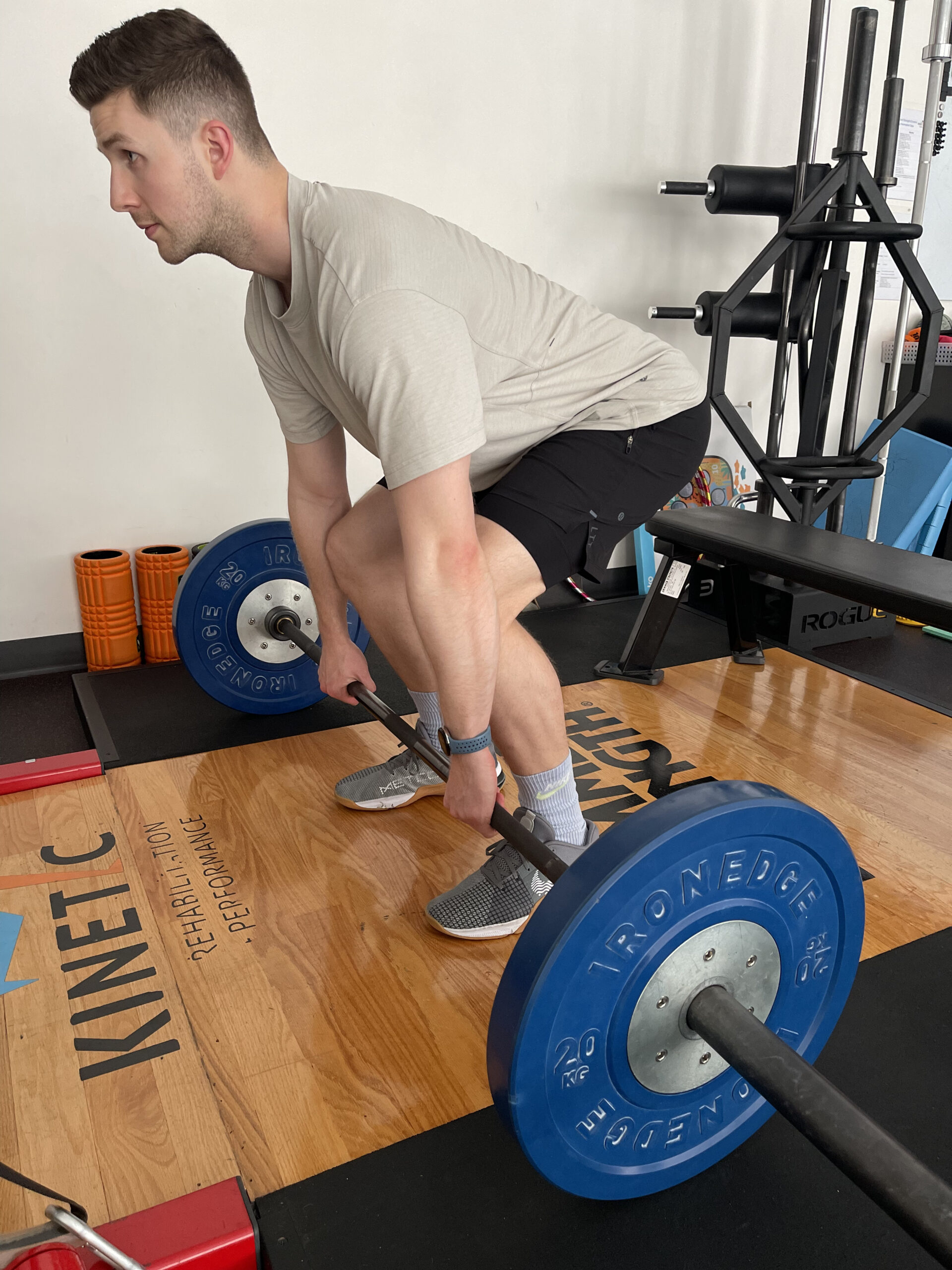 A man lifting weights with guidance from a sports physio in Adelaide