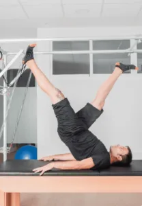 A man performing pilates exercises in a clinical pilates studio